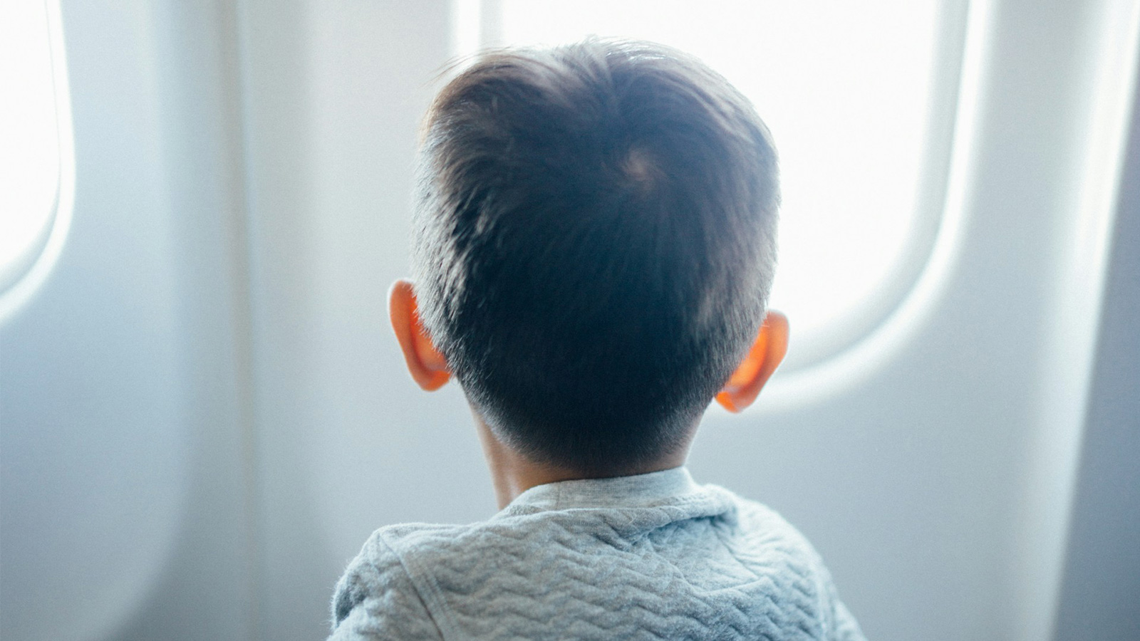 Child looking out plane window