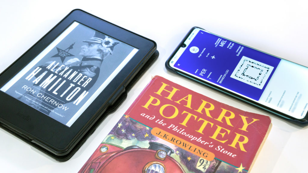 Kindle e-reader, Harry Potter paperback book comparison.