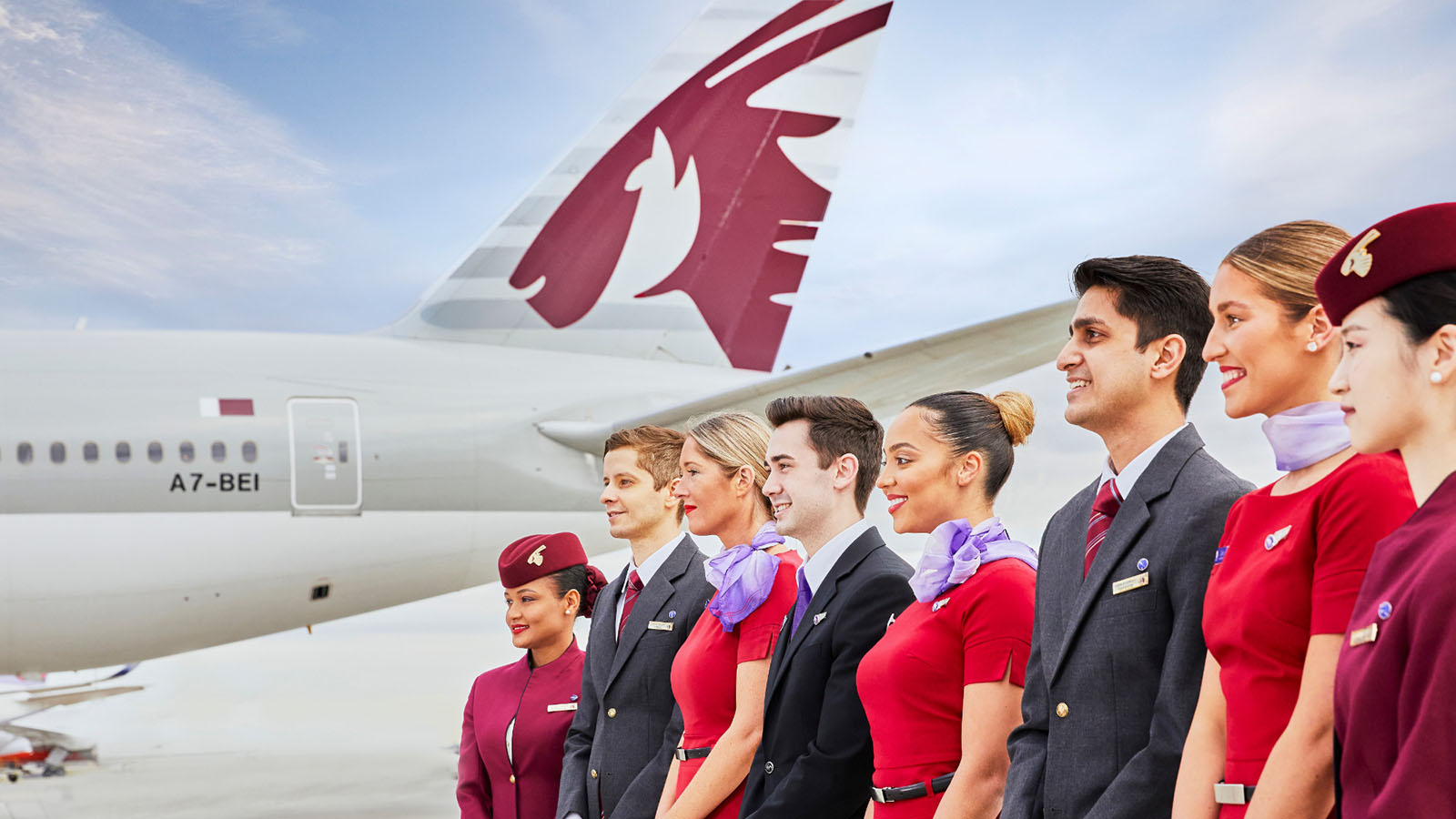 Virgin Australia and Qatar Airways cabin crew next to Qatar Airways aircraft