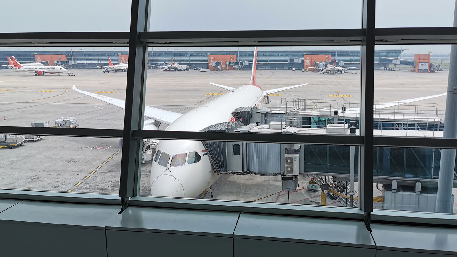 An Air India Boeing 787 jet sits at the gate in Delhi Airport as Business Class passengers prepare to board