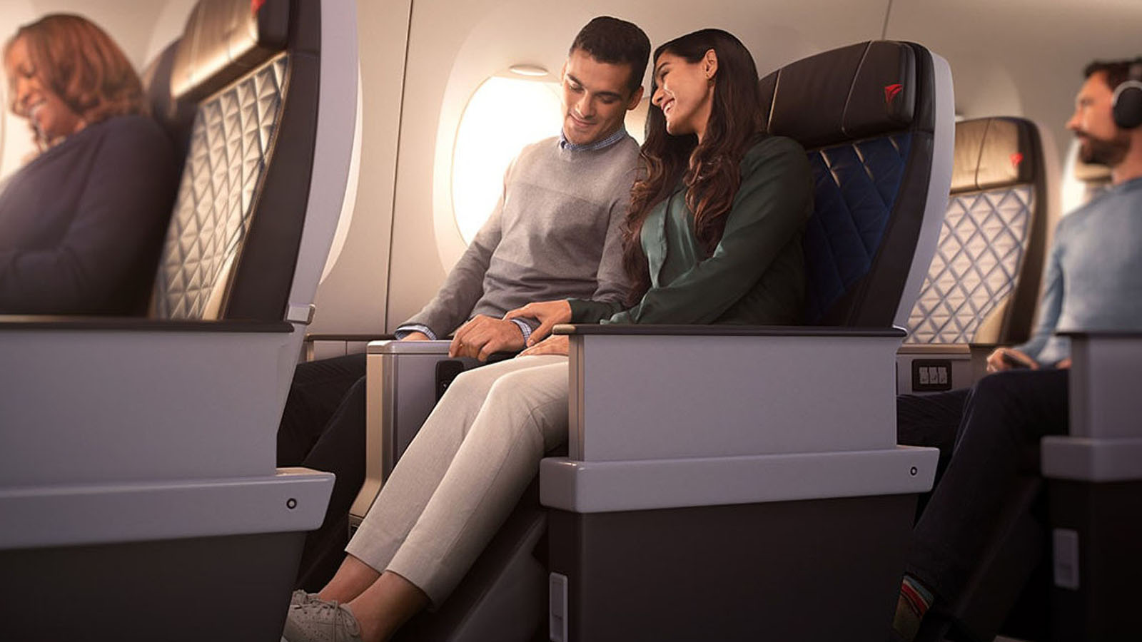 A couple relax in the Delta Premium Select cabin. Get a status match and fly Delta.
