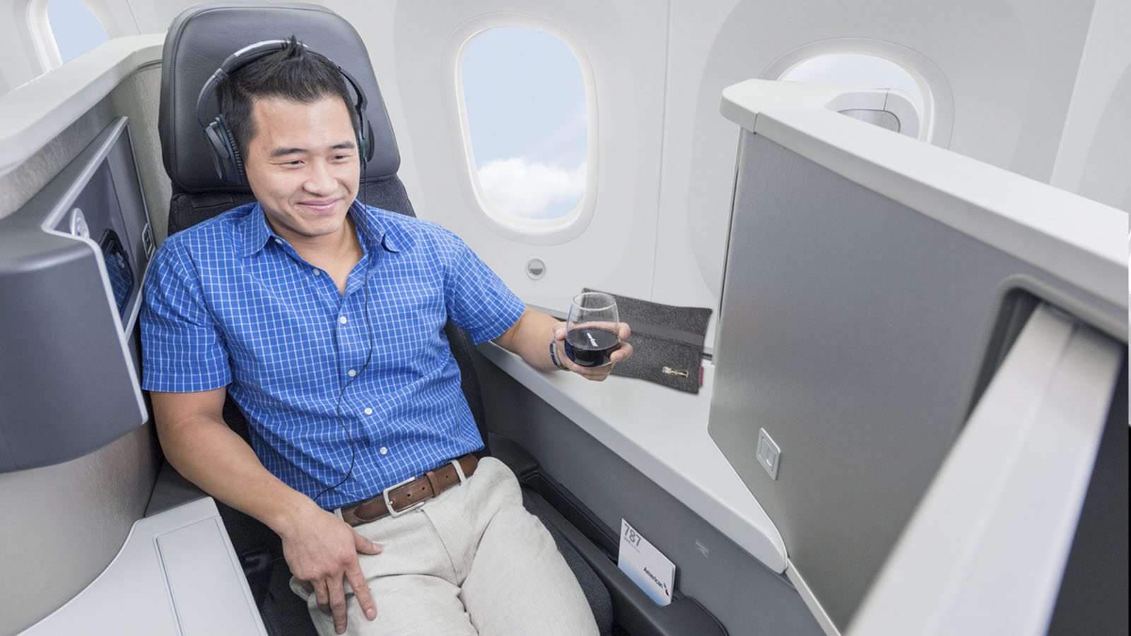 Passenger relaxing in American Airlines Business Class, bookable using Cathay miles