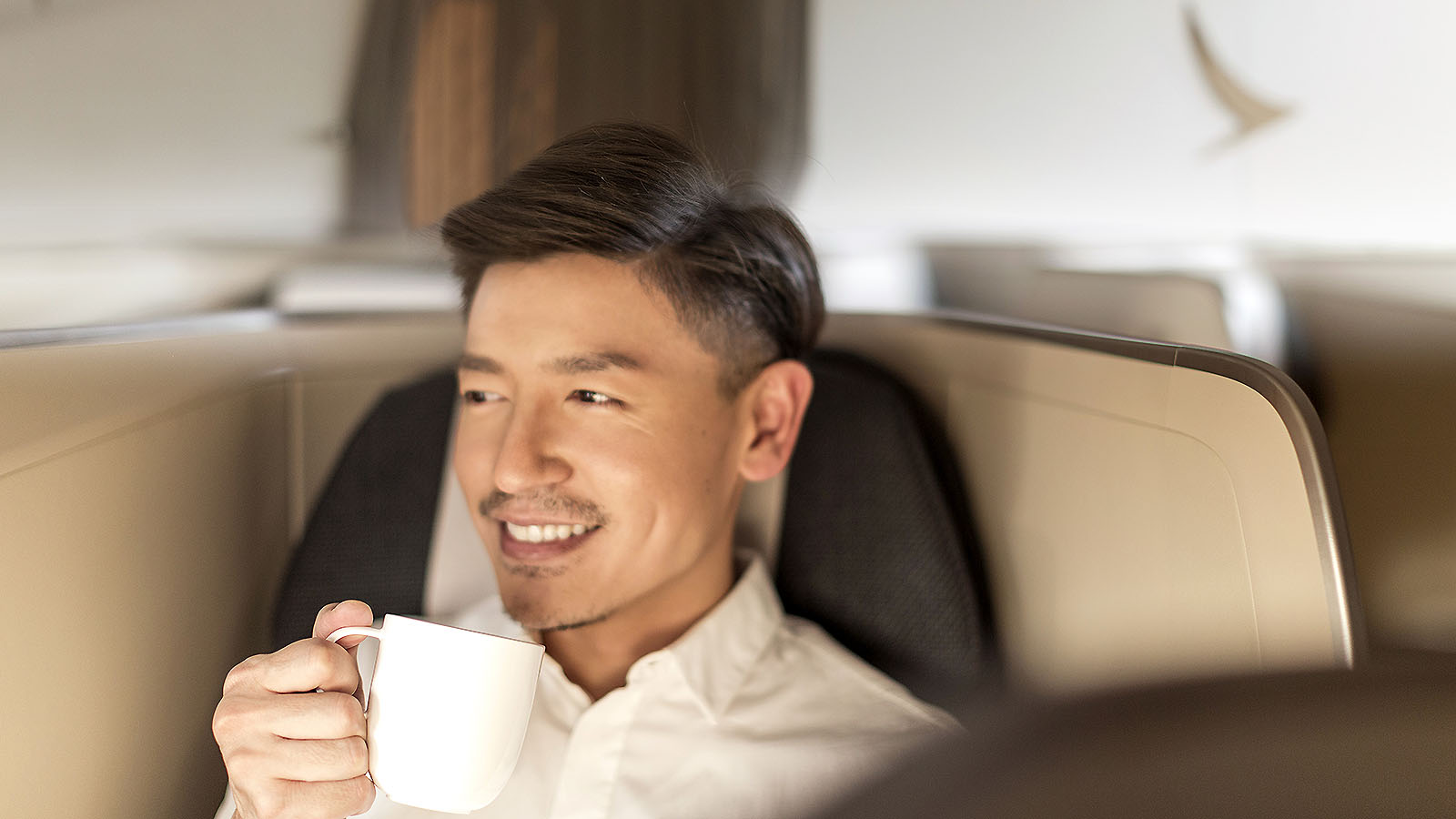 Cathay Pacific Diamond Plus member sits in Business Class seat