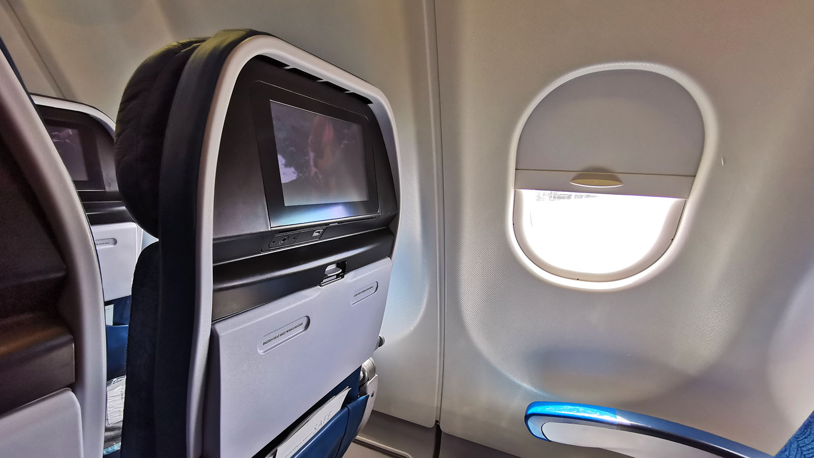 TV screen next to window on Hawaiian Airlines