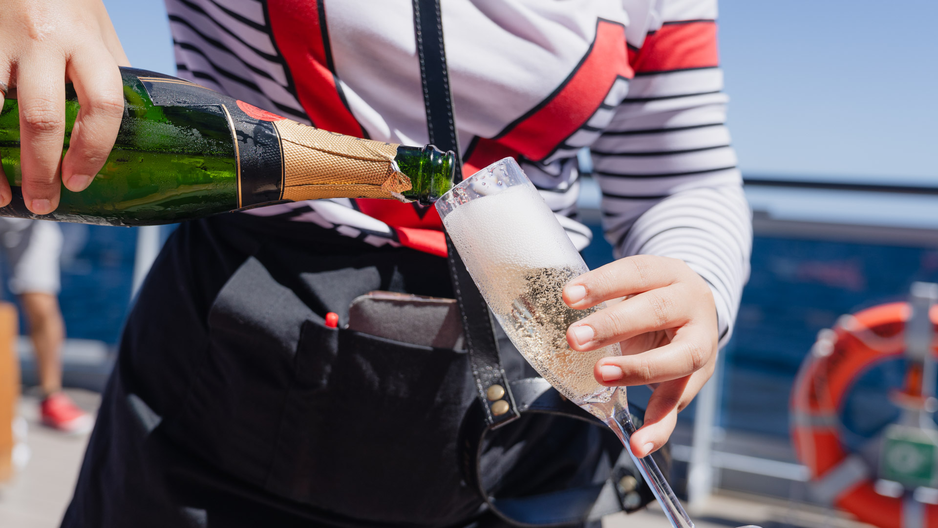 Virgin Voyages pouring Champagne