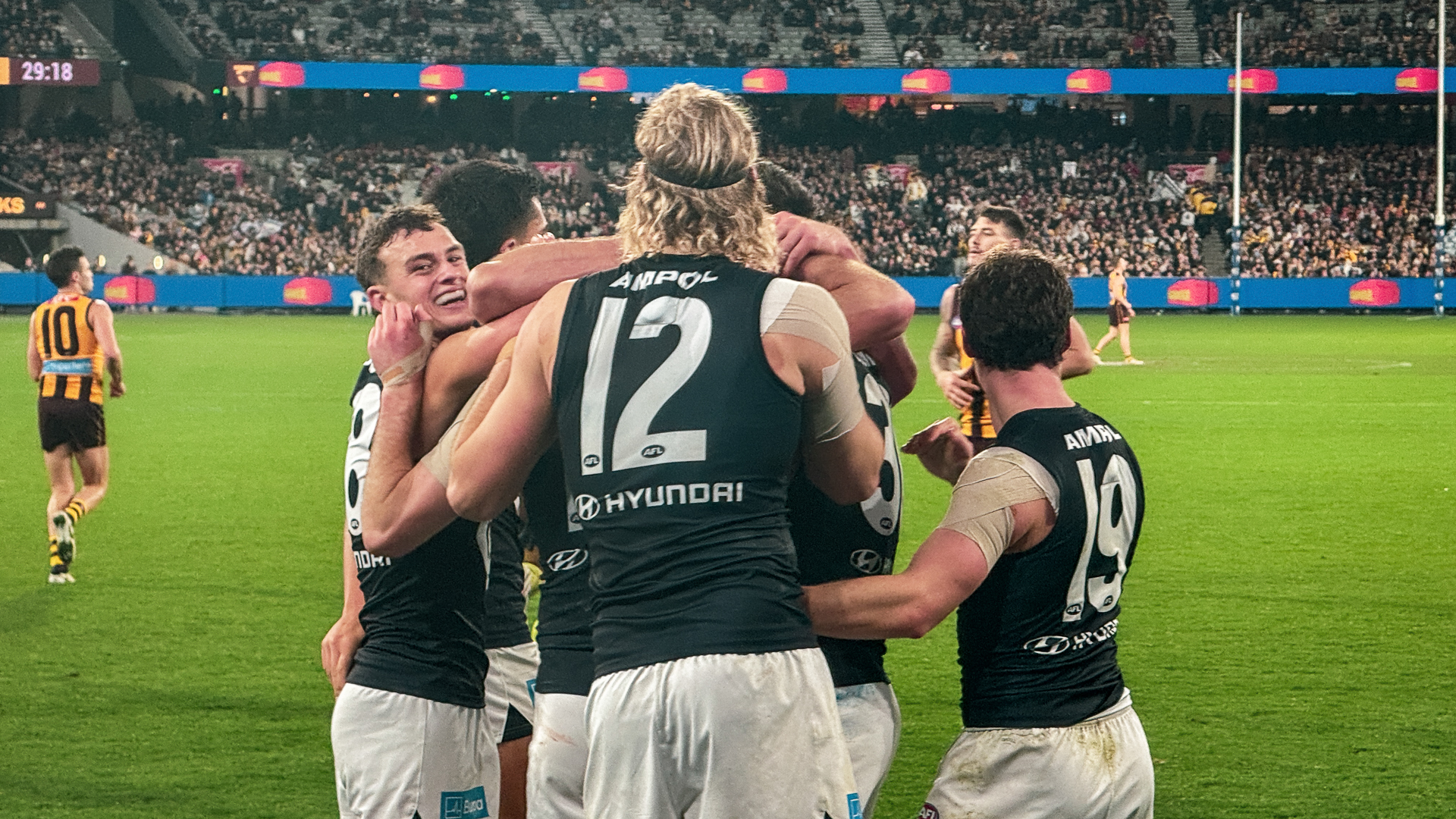 AFL Carlton players celebrating after a goal.