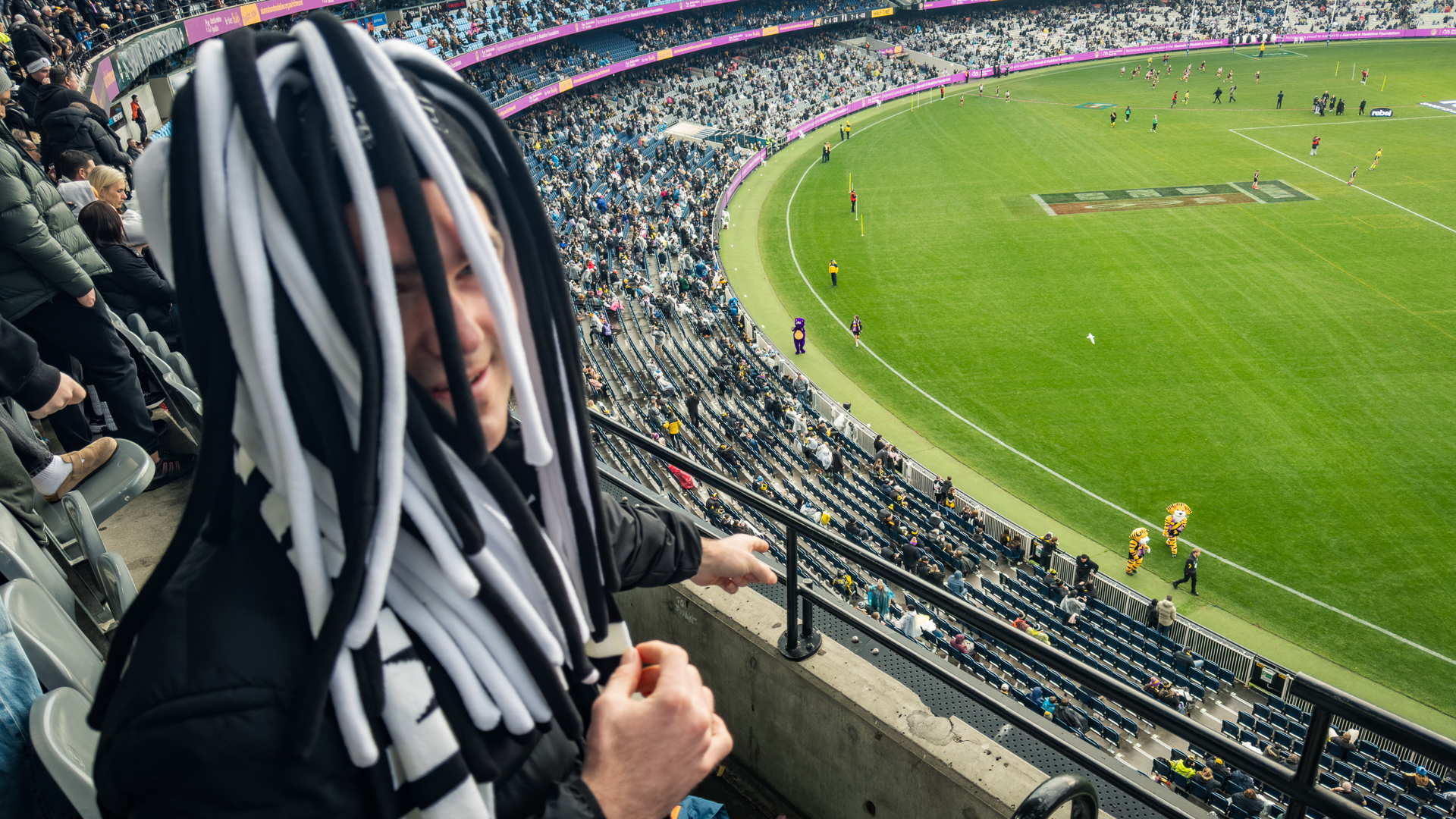 Joshua Weckert pointing at the Richmond tigers mascots from the stands.